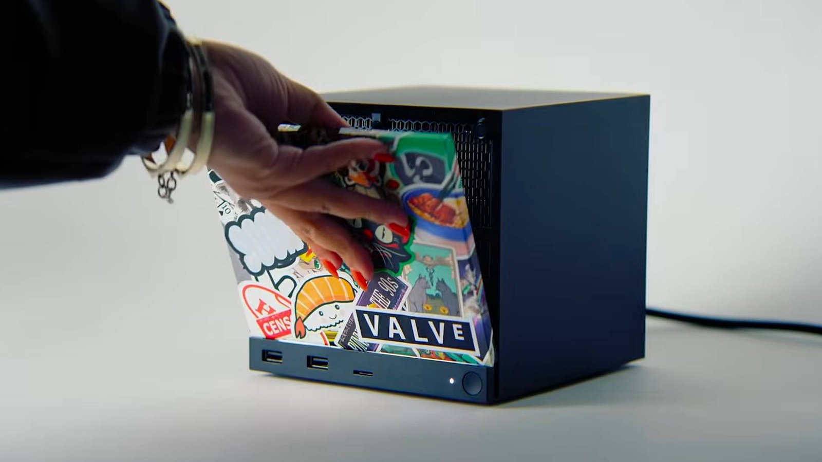 Hand placing custom face plate on Steam Machine mini PC.